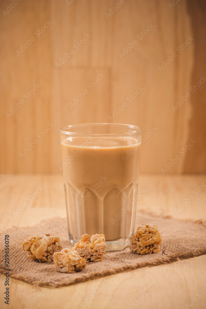 木桌上的奶瓶和牛奶杯。健康饮食理念