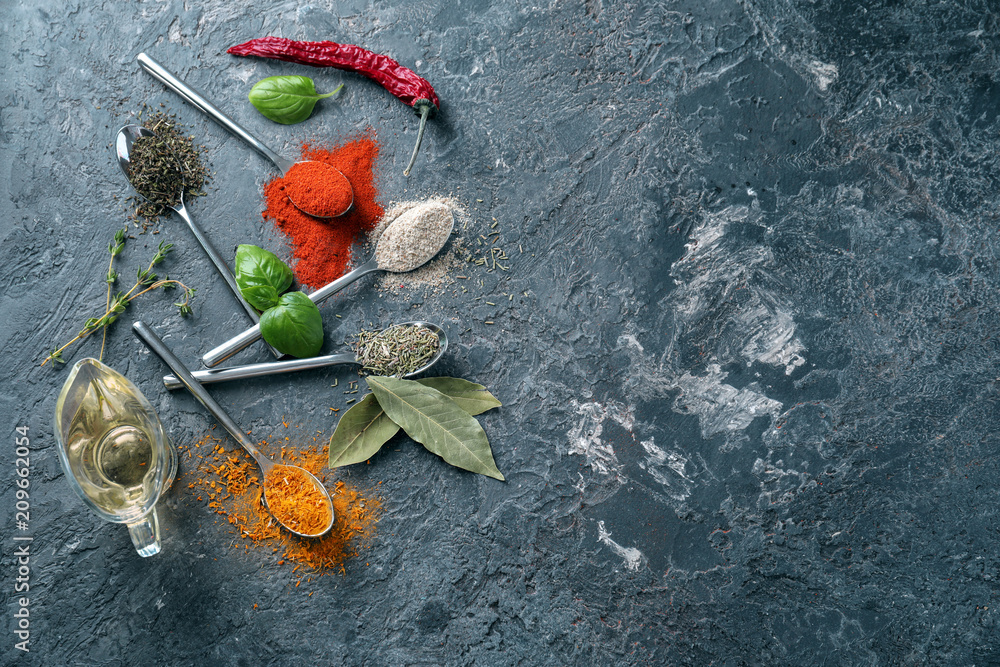 Different kinds of spices with oil on grey background