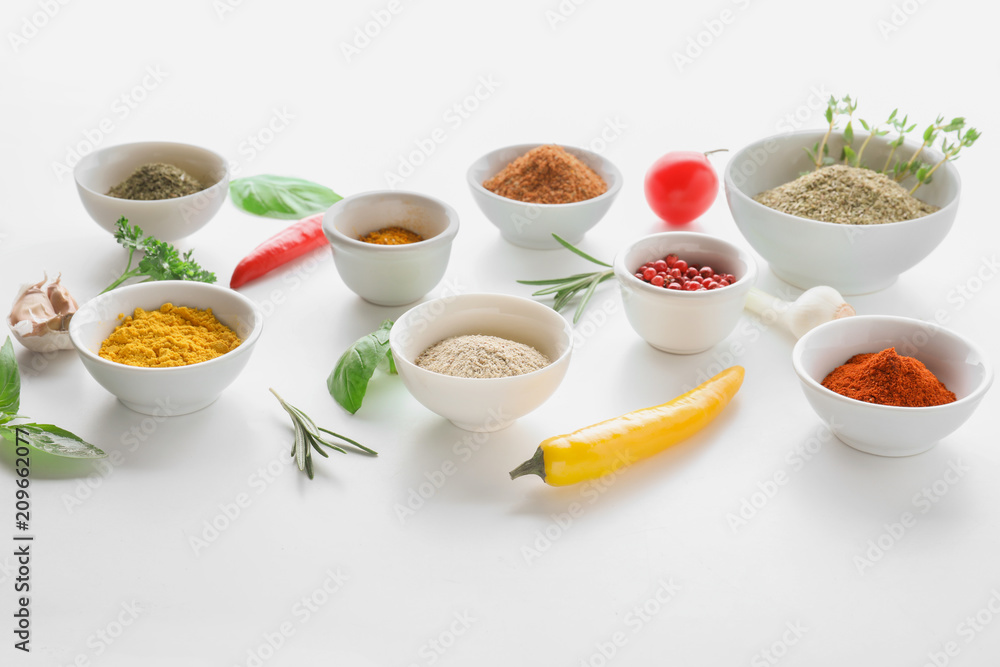 Bowls with various spices and herbs on white background