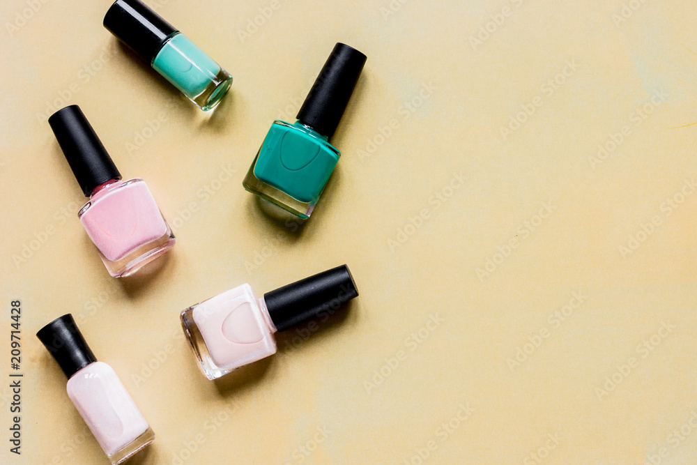 Bottles with nail polish over orange background top view mockup