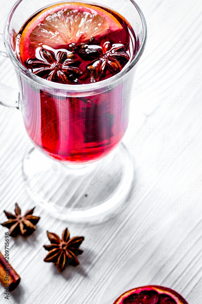 mulled wine with spices in cup on wooden background