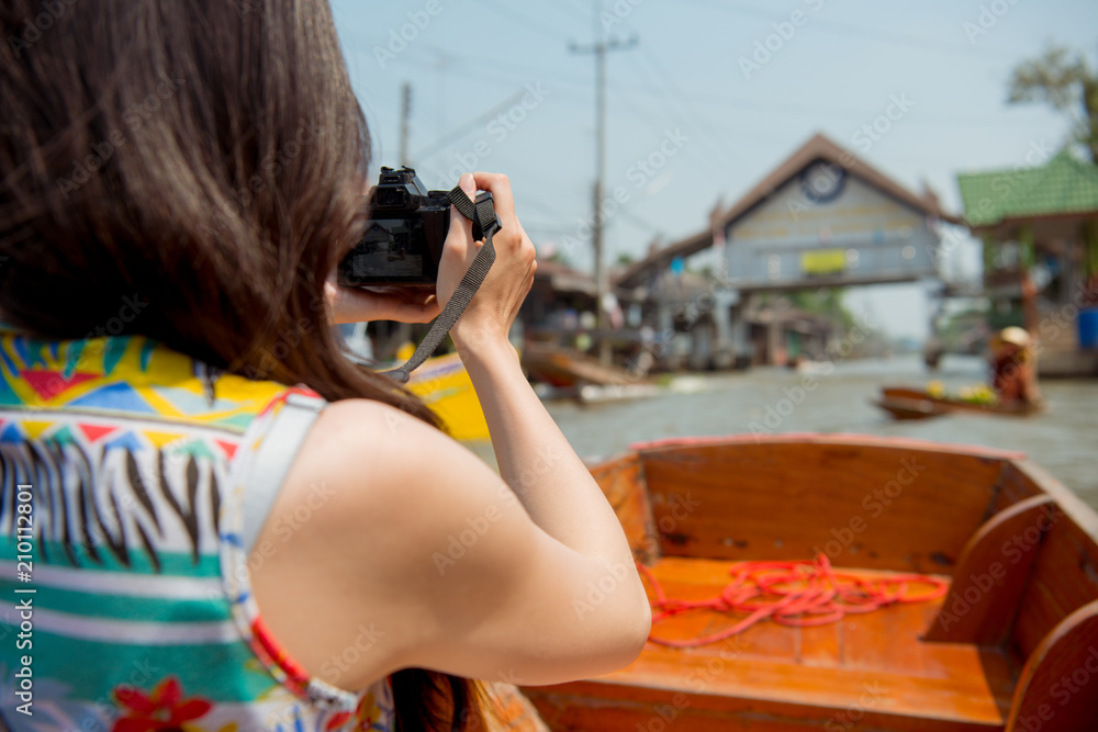 Tourist visiting floating market and taking photo