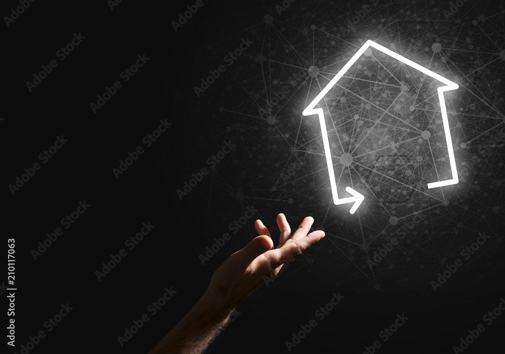 Conceptual image with hand pointing at house or main page icon on dark background