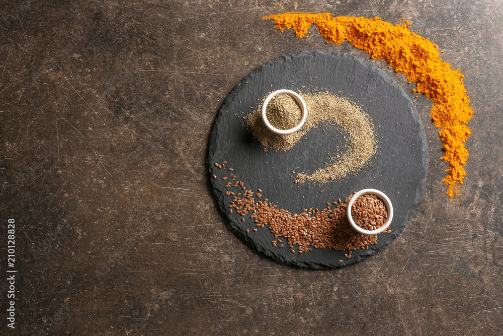 Slate plate with various spices on grey background