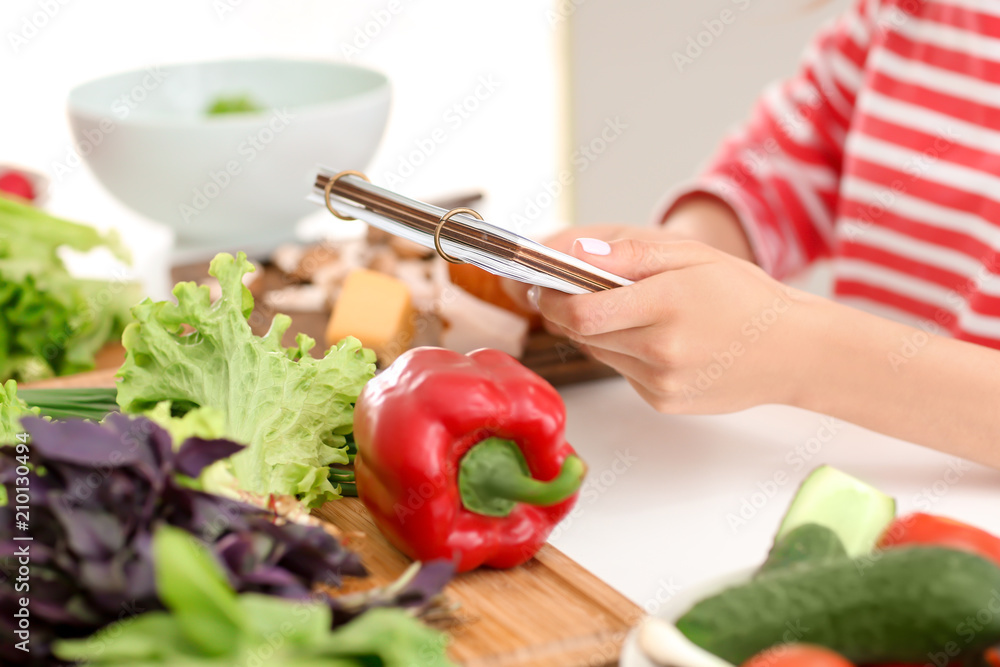 年轻女人在厨房里读食谱