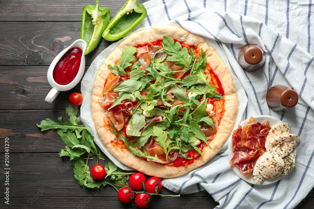 Raw pizza with tomato sauce and ingredients on table