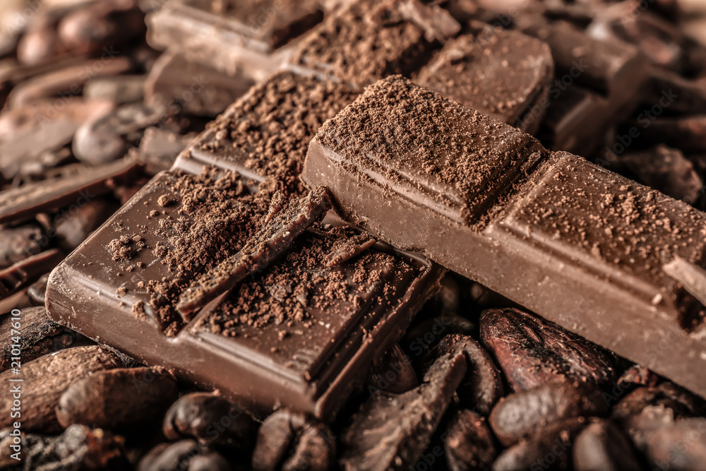 Tasty milk chocolate, coffee beans and cocoa products, closeup