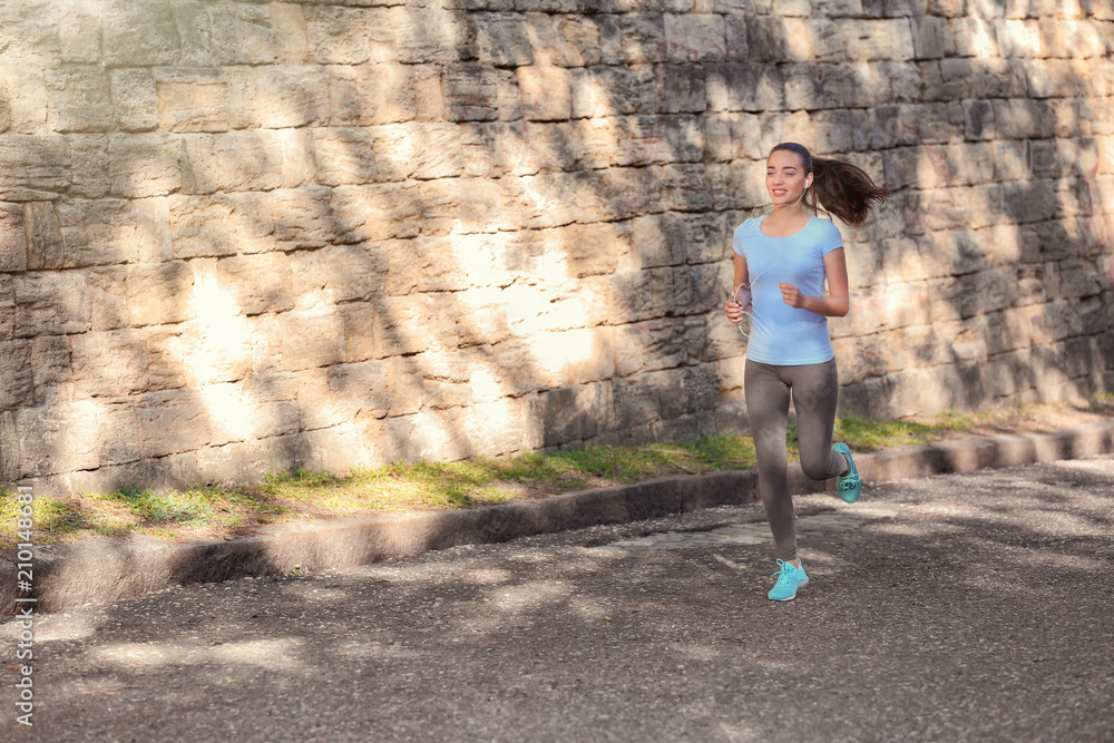 Sporty young woman running outdoors