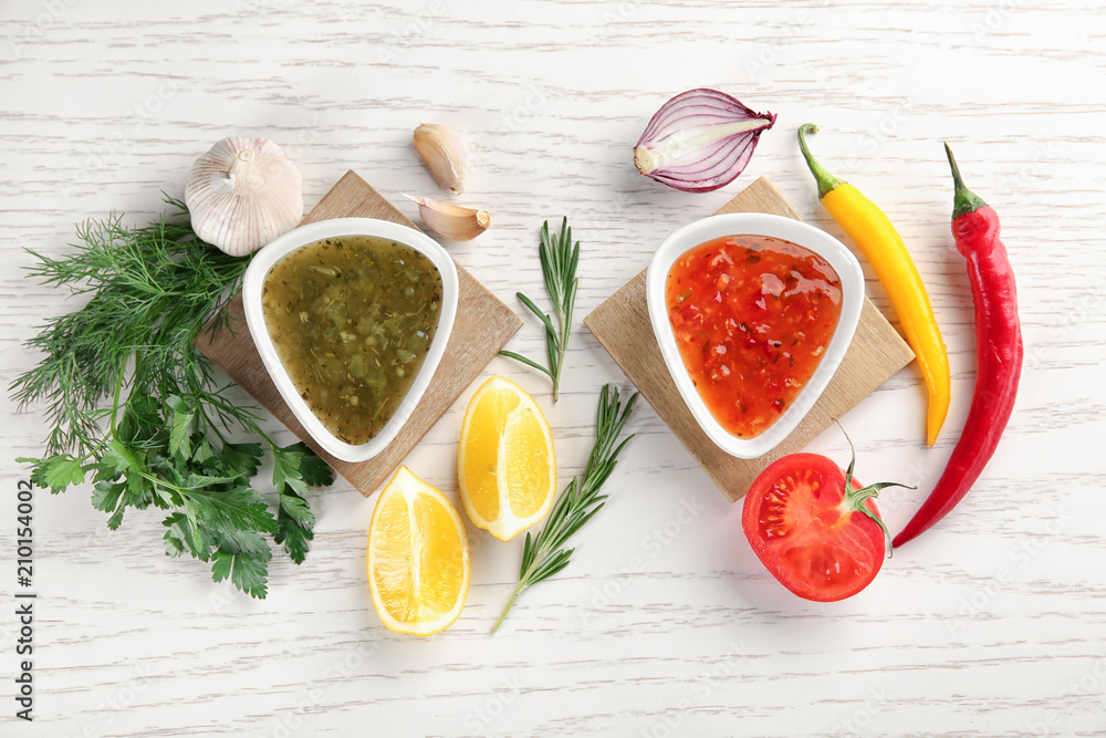 Composition with different sauces on white wooden table, top view