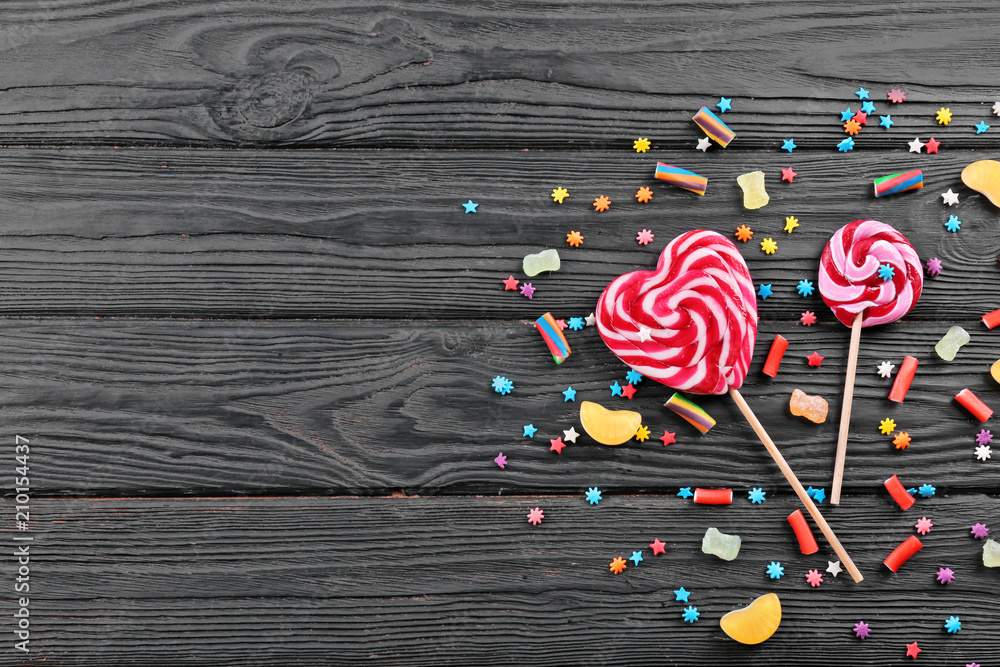 Colorful candies on wooden background, top view