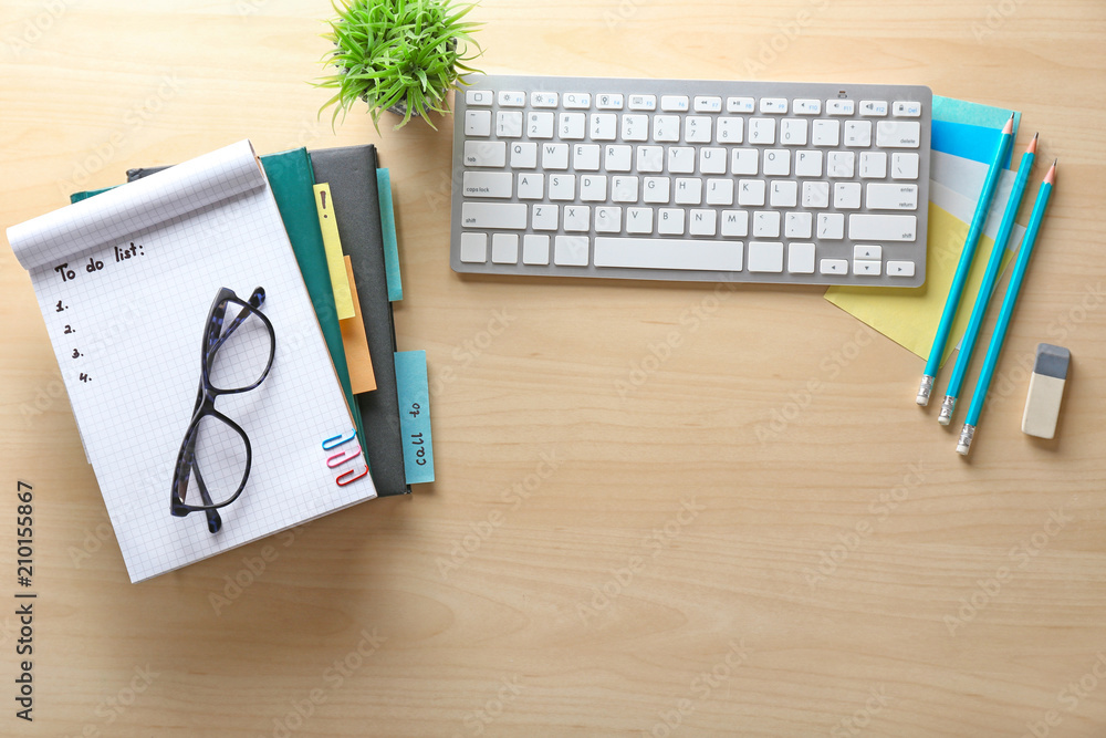 Empty to-do list with computer keyboard on wooden background