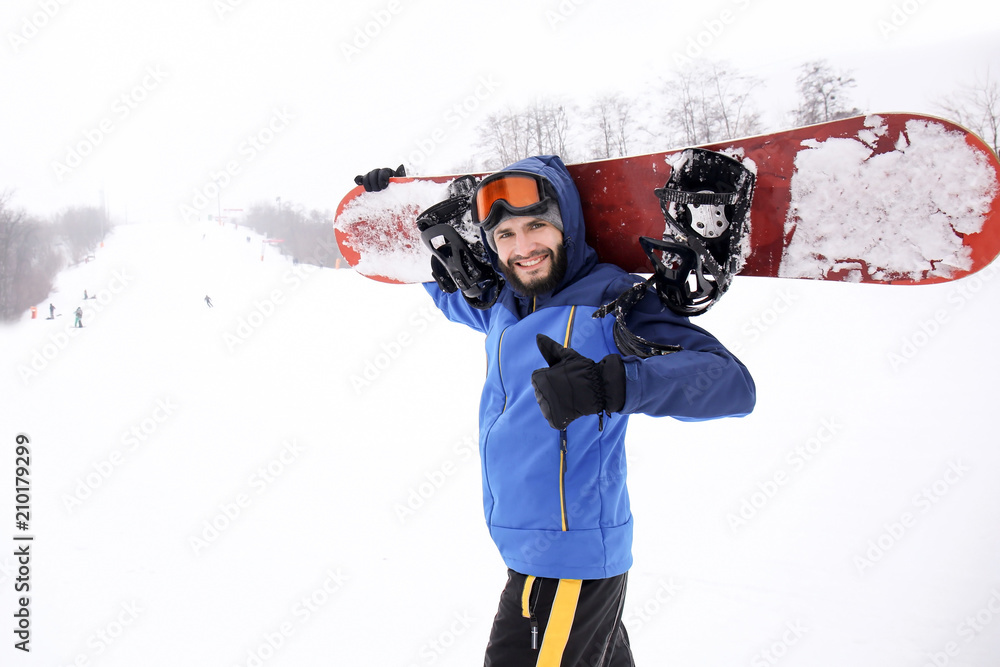 冬季度假区斜坡上的男单板滑雪运动员