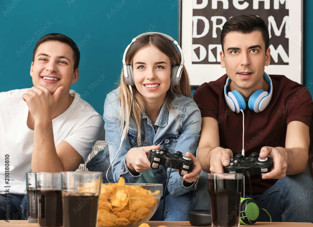 Young people playing video games at home