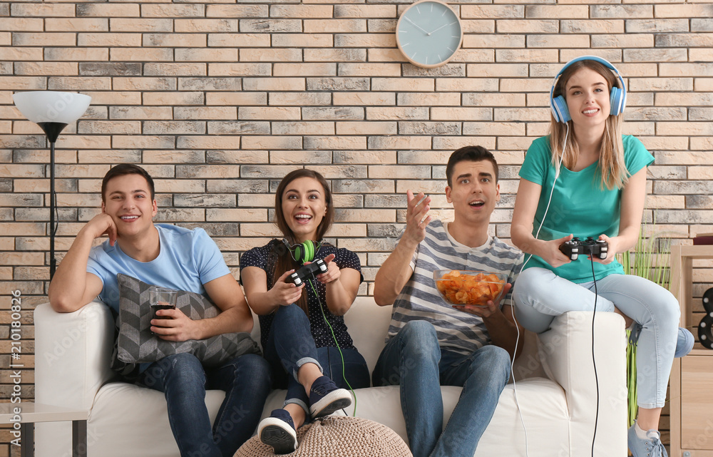 Young people playing video games at home