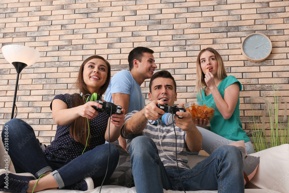 Young people playing video games at home