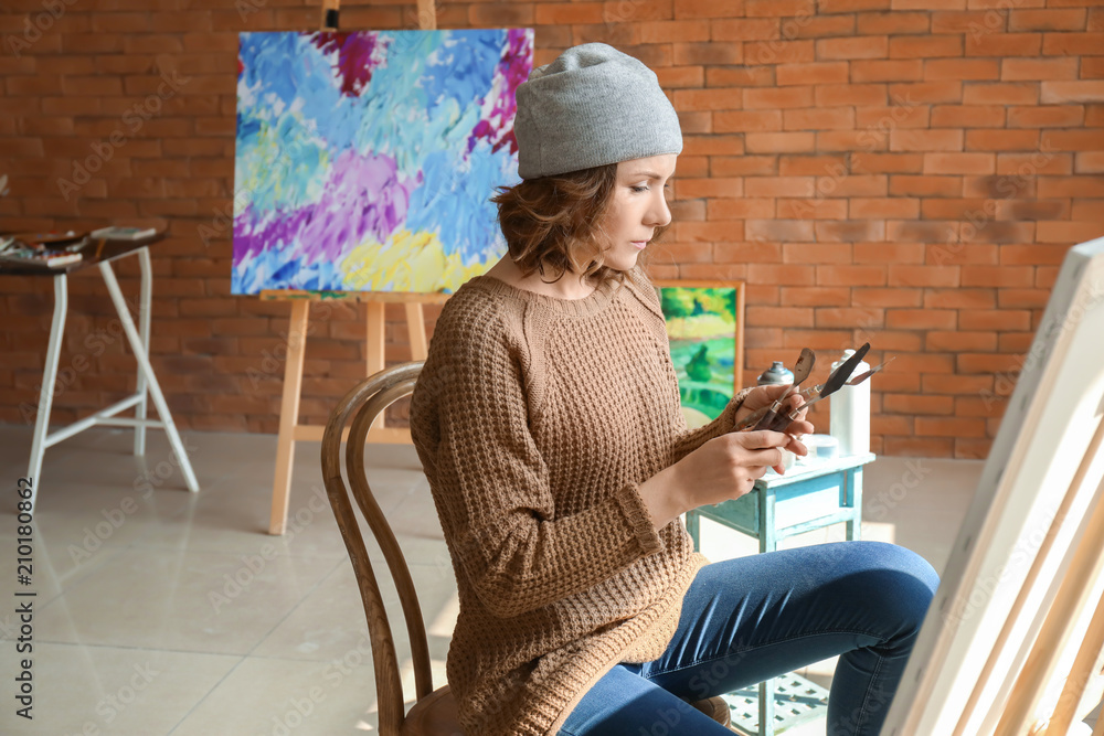 Female artist painting in workshop