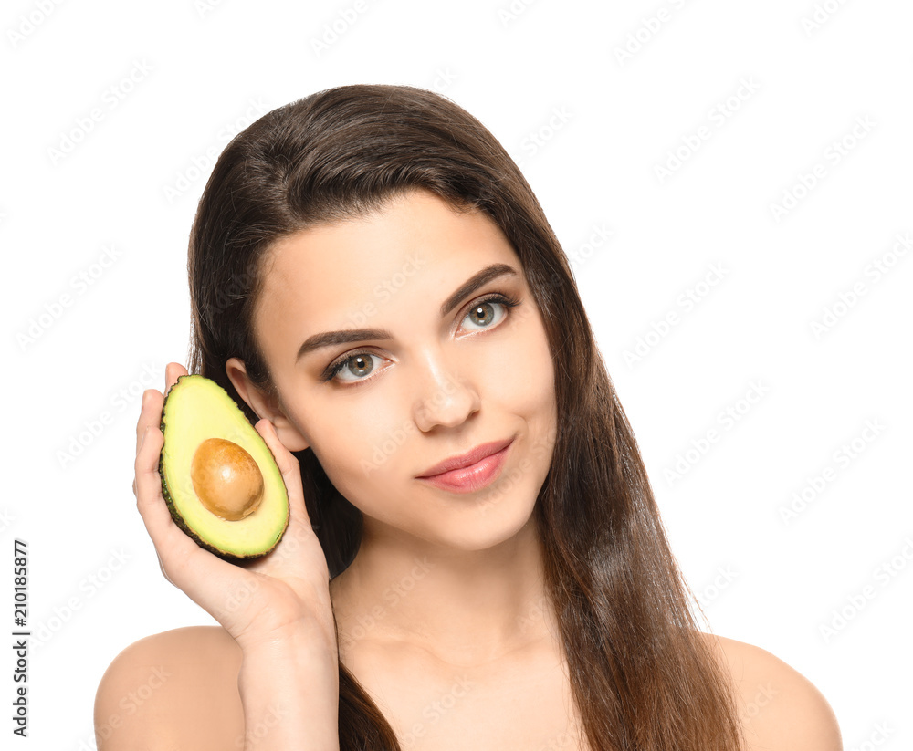 Beautiful young woman with avocado on white background