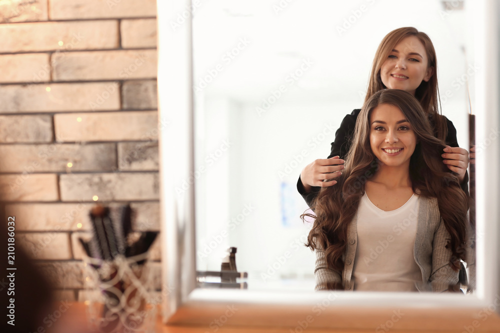 Professional hairdresser working with client in salon