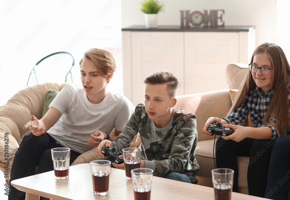 Teenagers playing video games at home