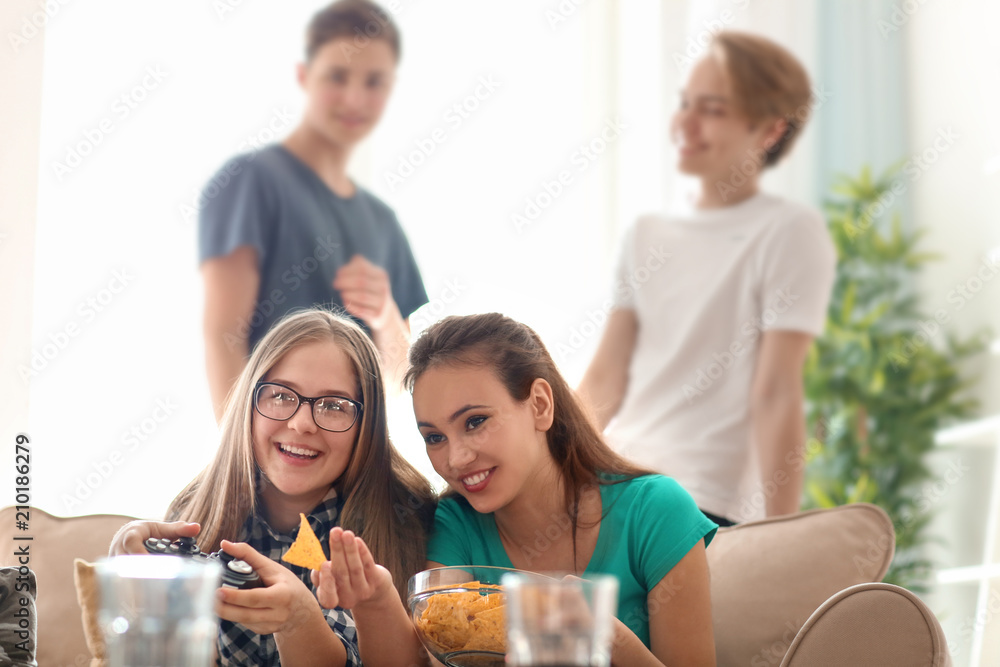 Teenagers playing video games at home