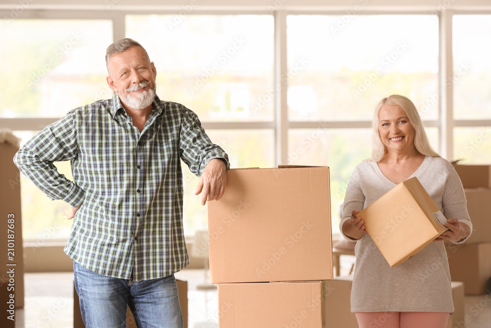 Mature couple with moving boxes at new home