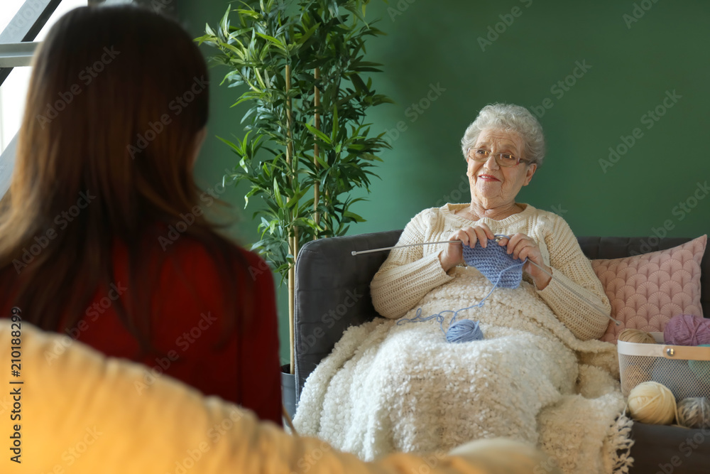 年轻女子和奶奶在家一起编织