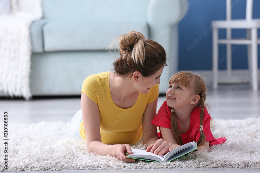 Mother and her daughter reading book together at home