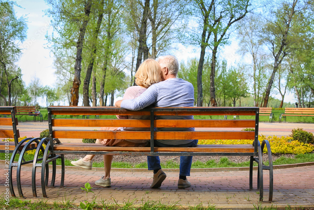 Mature couple resting in park on spring day