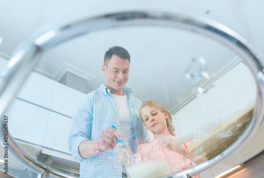 Dad and daughter preparing a cake in the kitchen