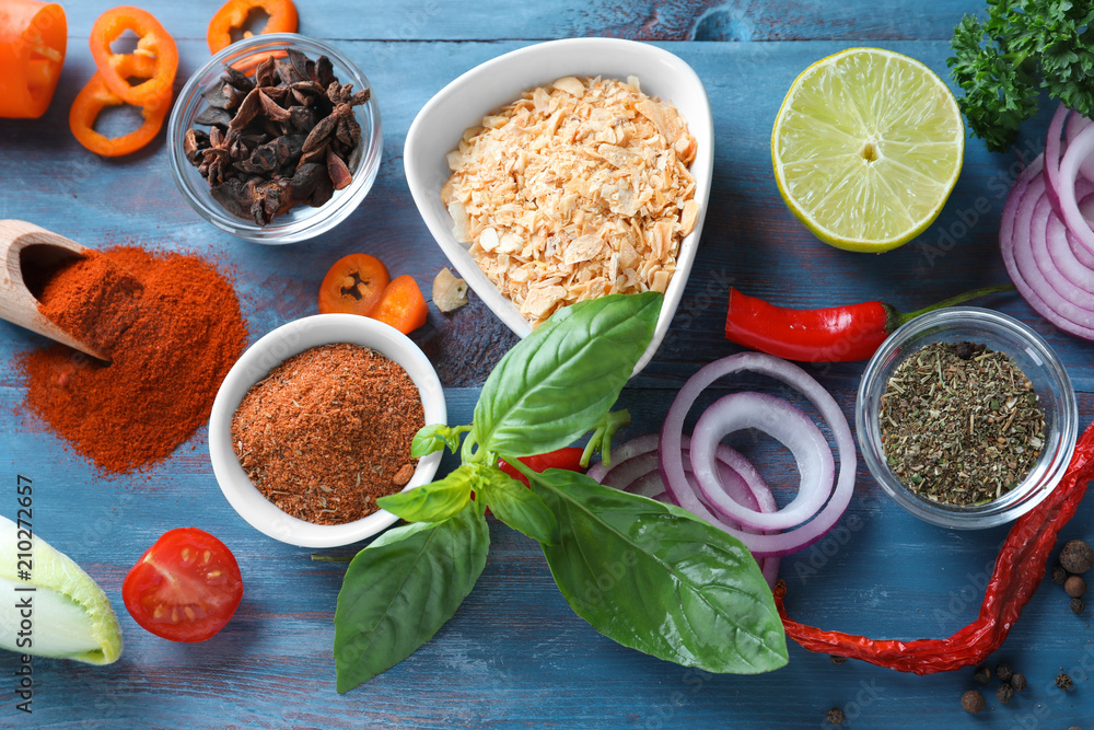 Various spices with vegetables on wooden background