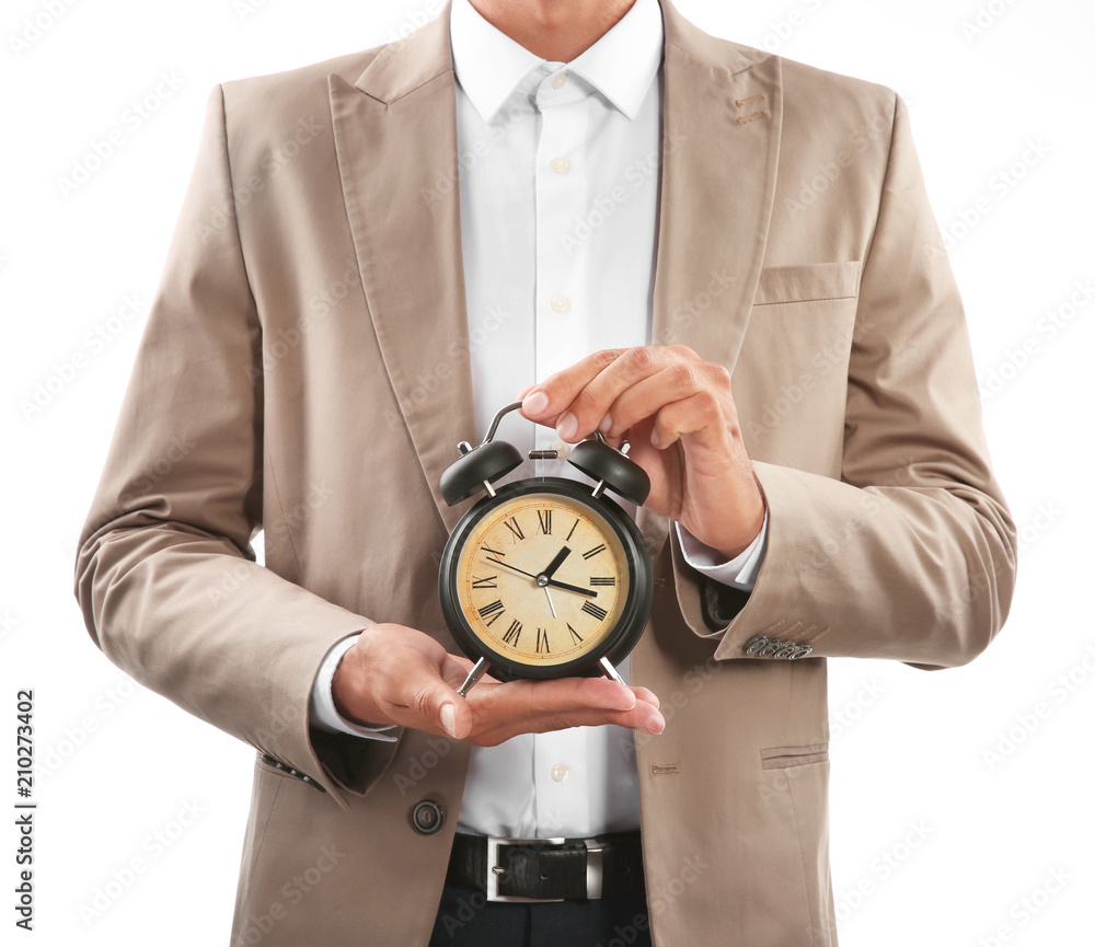 Businessman holding alarm clock on white background. Time management concept