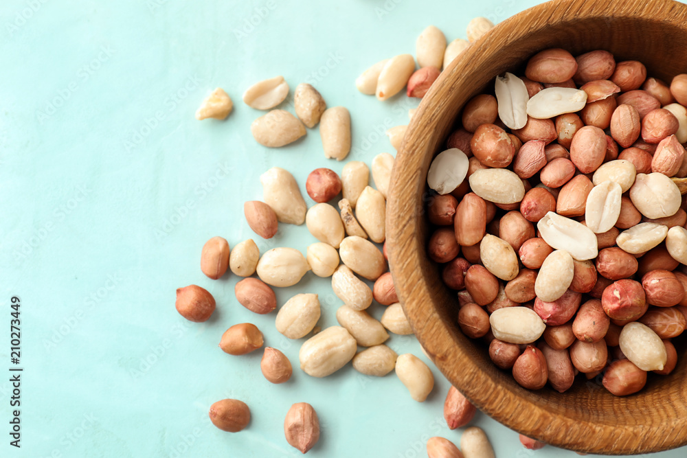 Bowl with tasty peanuts on table