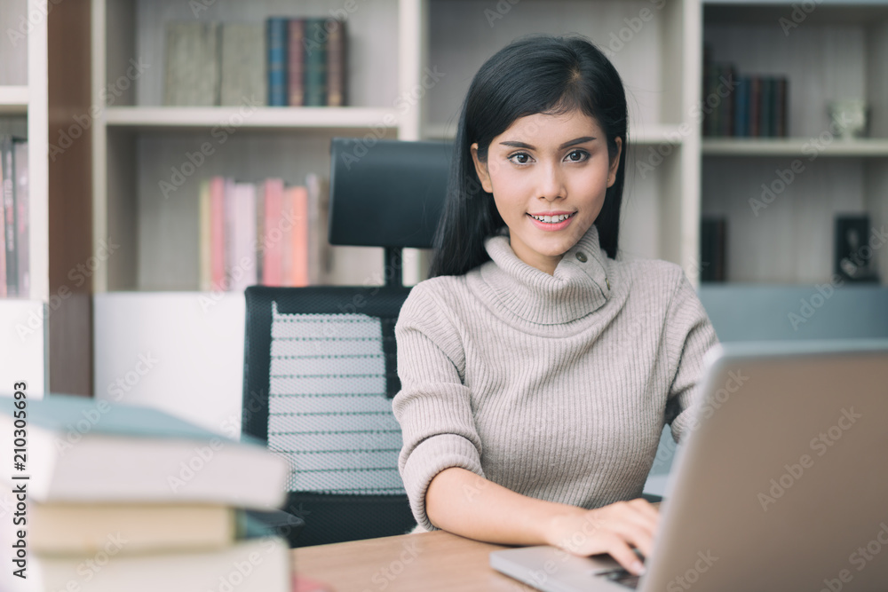 Asian young smart woman manager with casual doing her business work with laptop and sitting on chair