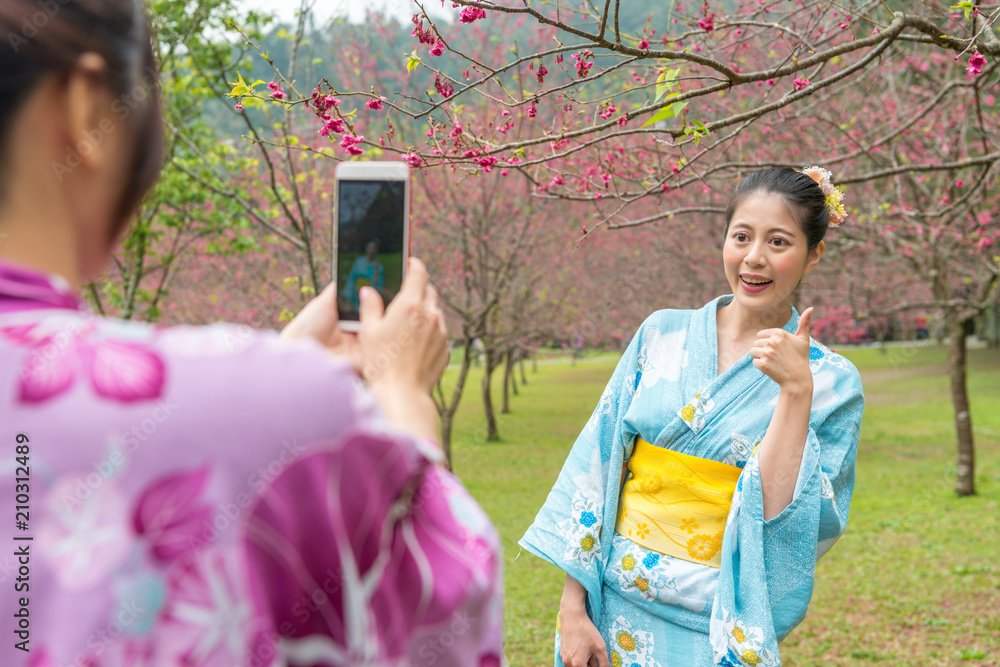 女士摆出大拇指拍照