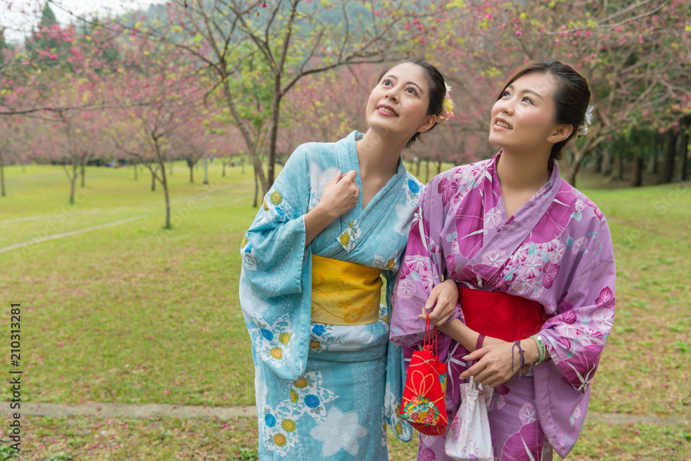 两个年轻的亚洲女孩站在一起散步