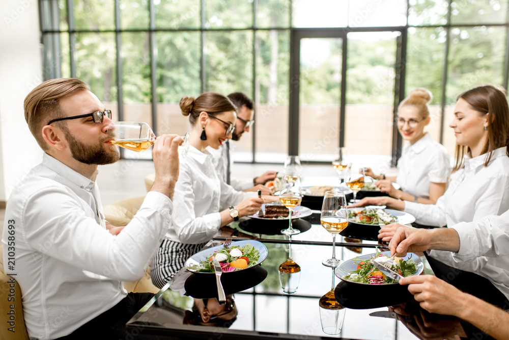 Business people dressed in white shirts sitting together during a business lunch with delicious meal