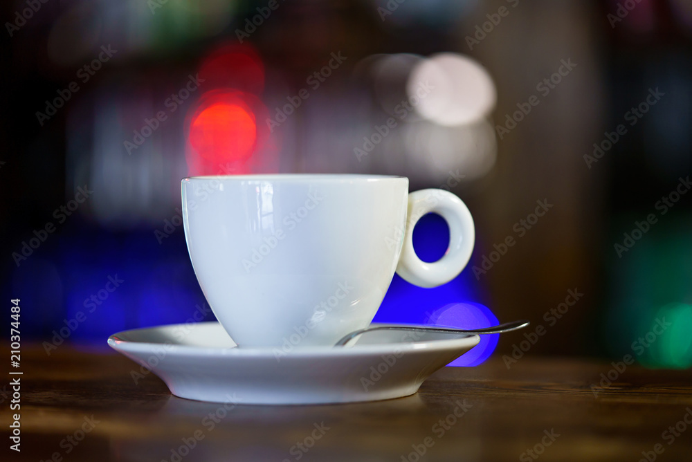 White cup of coffee at the cafe interior. Coffee cup in coffee shop