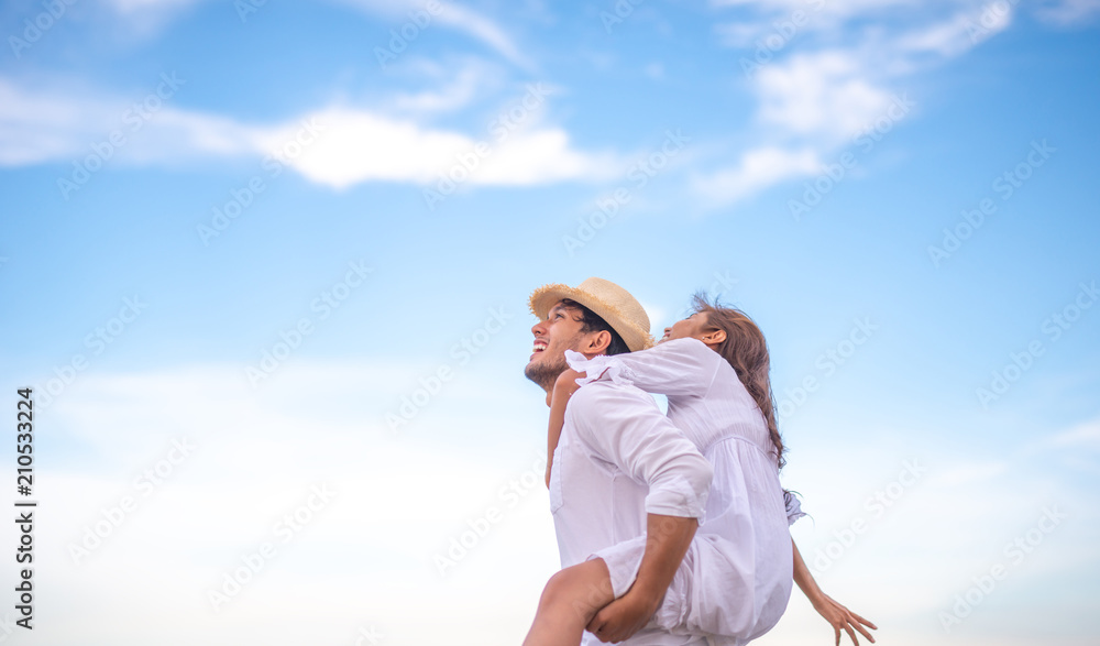 Happy relaxing couple in love on beach summer vacations. Joyful girl piggybacking on young boyfriend