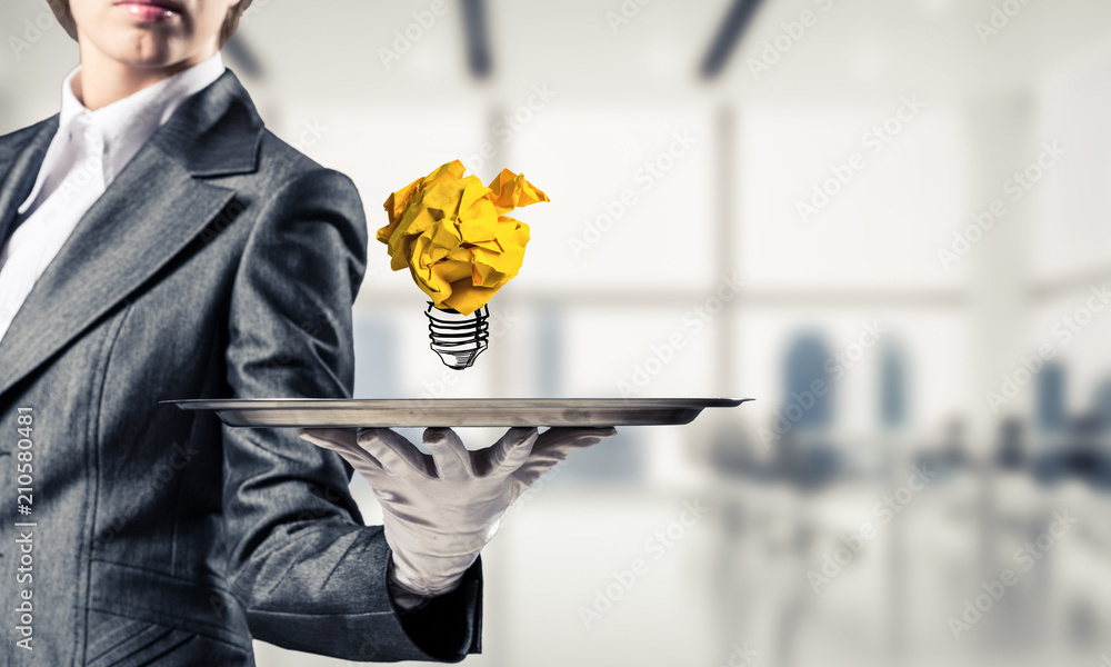 Hand of waiter presenting crampled paper lightbulb