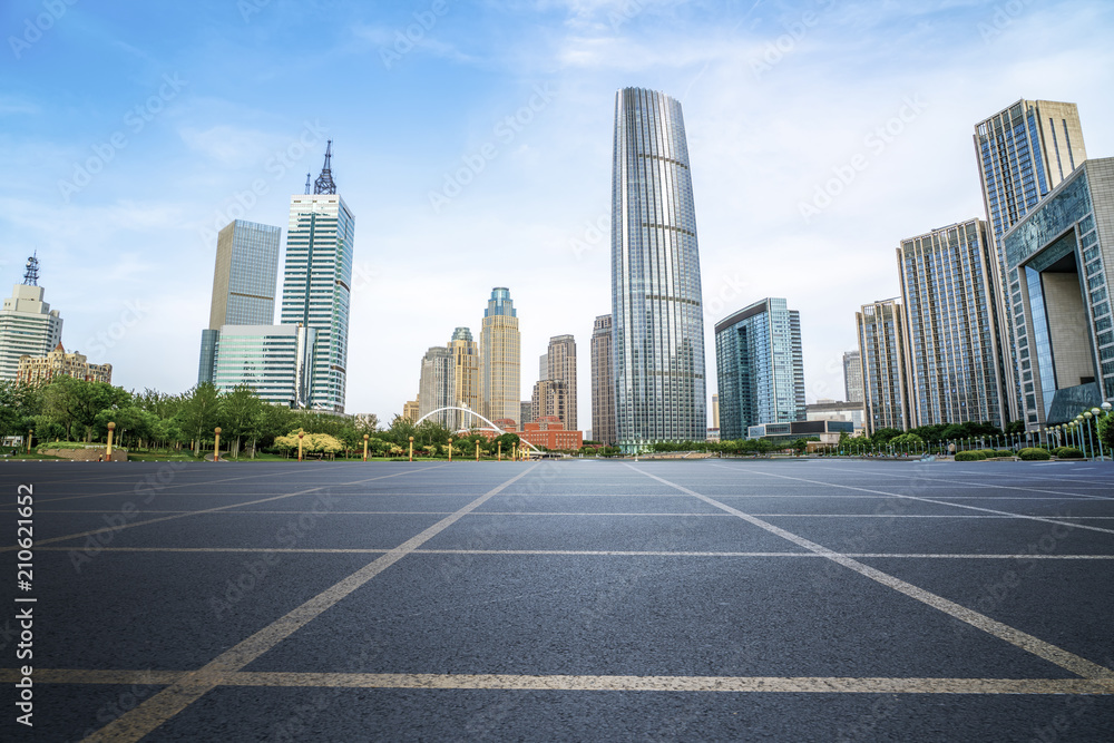 The empty asphalt road is built along modern commercial buildings in Chinas cities.