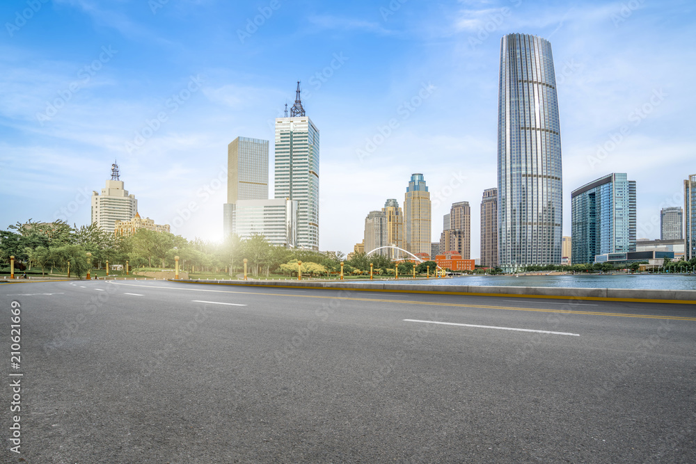 The empty asphalt road is built along modern commercial buildings in Chinas cities.