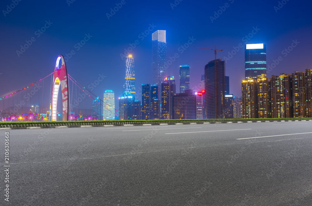 The empty asphalt road is built along modern commercial buildings in Chinas cities.