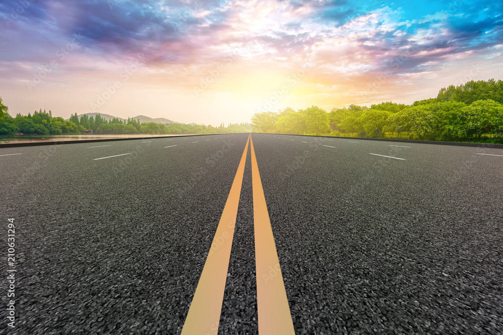 The empty asphalt road and natural landscape under the blue sky