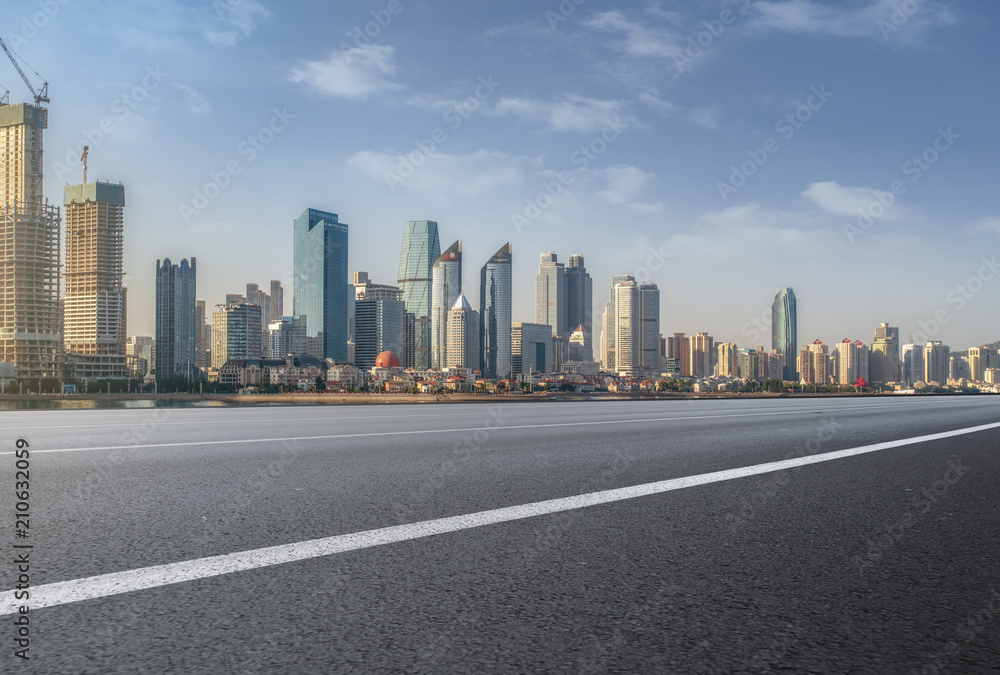 The empty asphalt road is built along modern commercial buildings in Chinas cities.