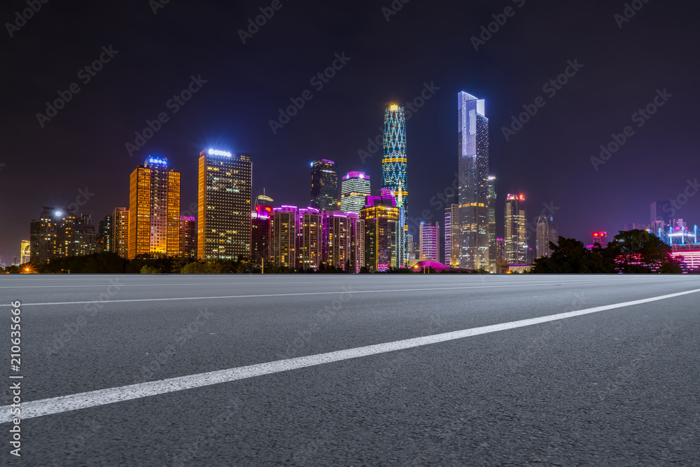 The empty asphalt road is built along modern commercial buildings in Chinas cities.