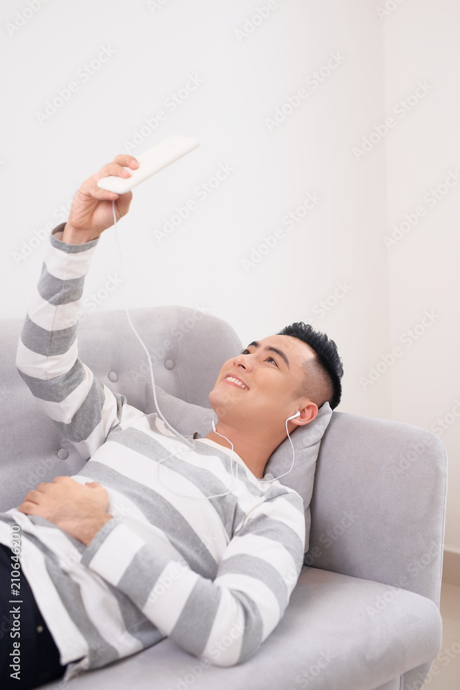 Man at home on sofa listening a music with a smartphone