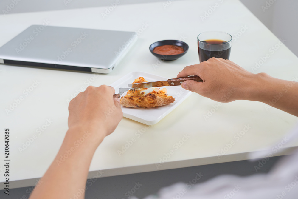 slice of pizza on white plate on wooden table with female hands