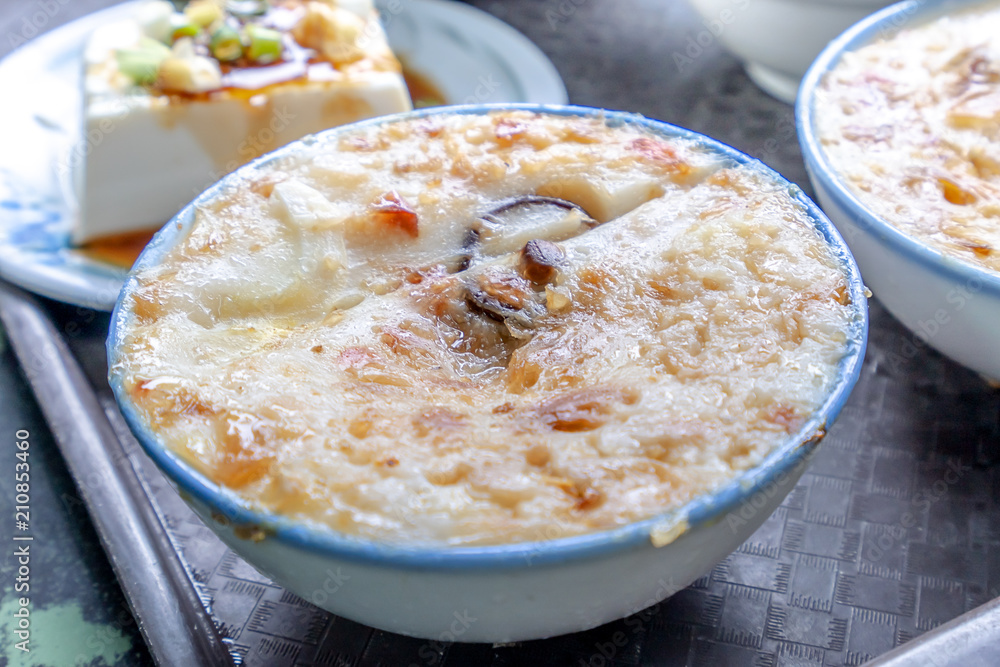 Taiwans distinctive famous snacks: Savory rice pudding (Wa gui) in a white bowl on stone table, Tai