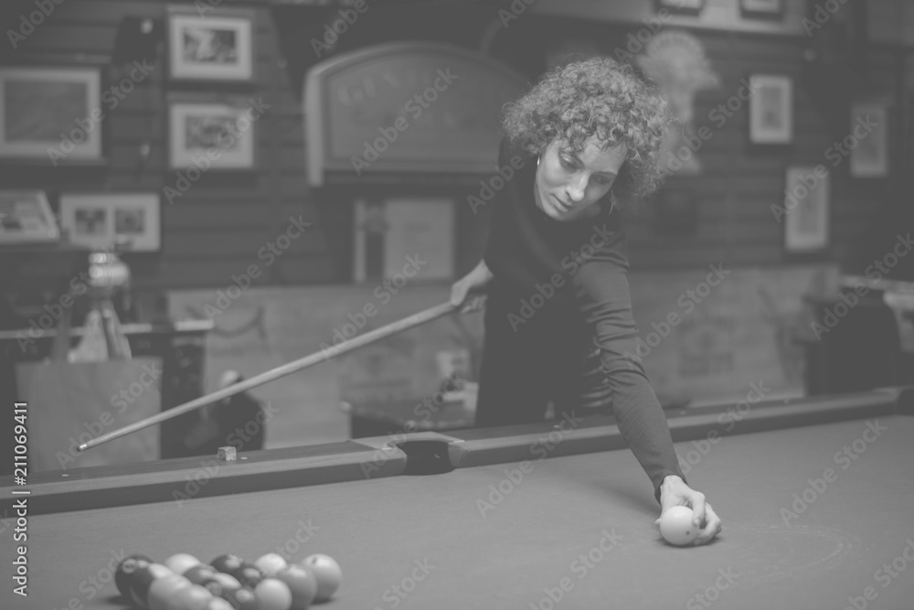 Woman playing pool at a bar