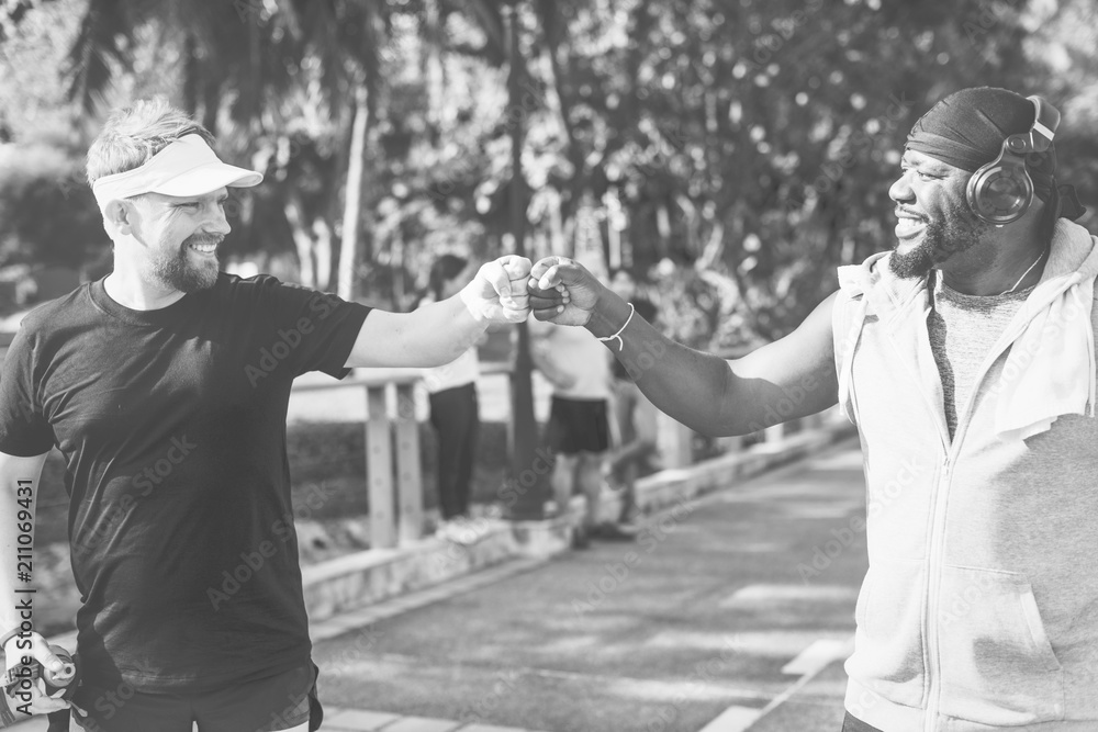 Men giving a fist bump while jogging